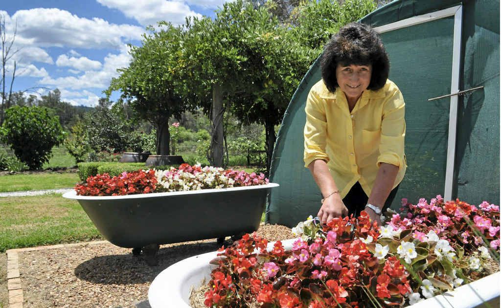 Kaye Mundey tends to flowers, planted in two old bathtubs. Kaye Mundey tends to flowers, planted in two old bathtubs.